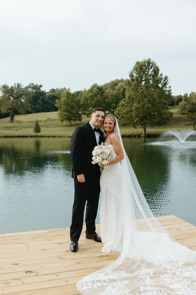 bride and groom on dock by a lake